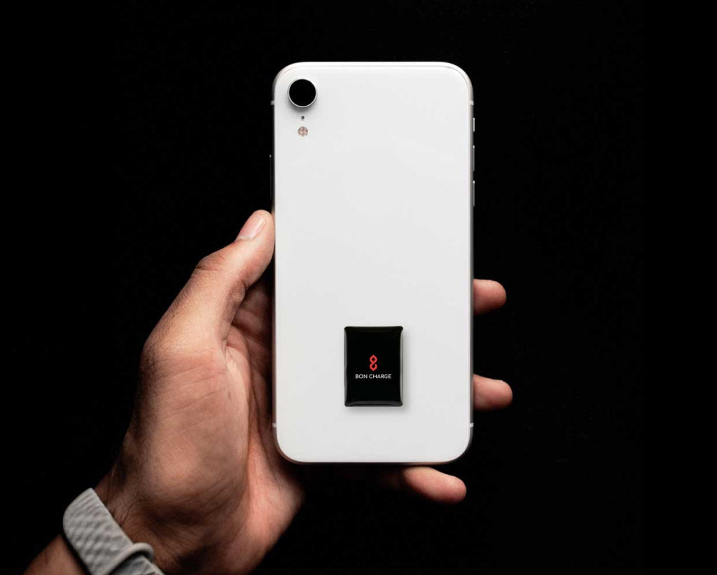 Someone Holding Phone With Harmonising Sticker On Back