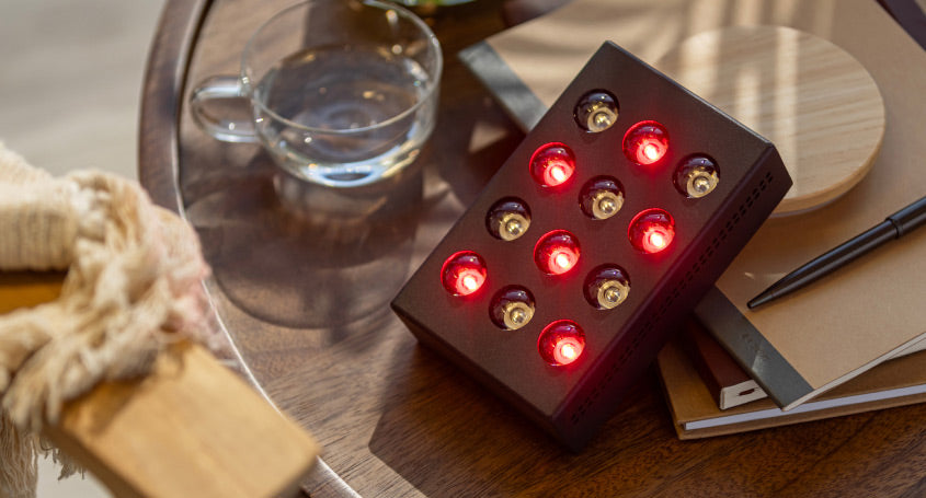 Mini device glowing red resting on some books on coffee table